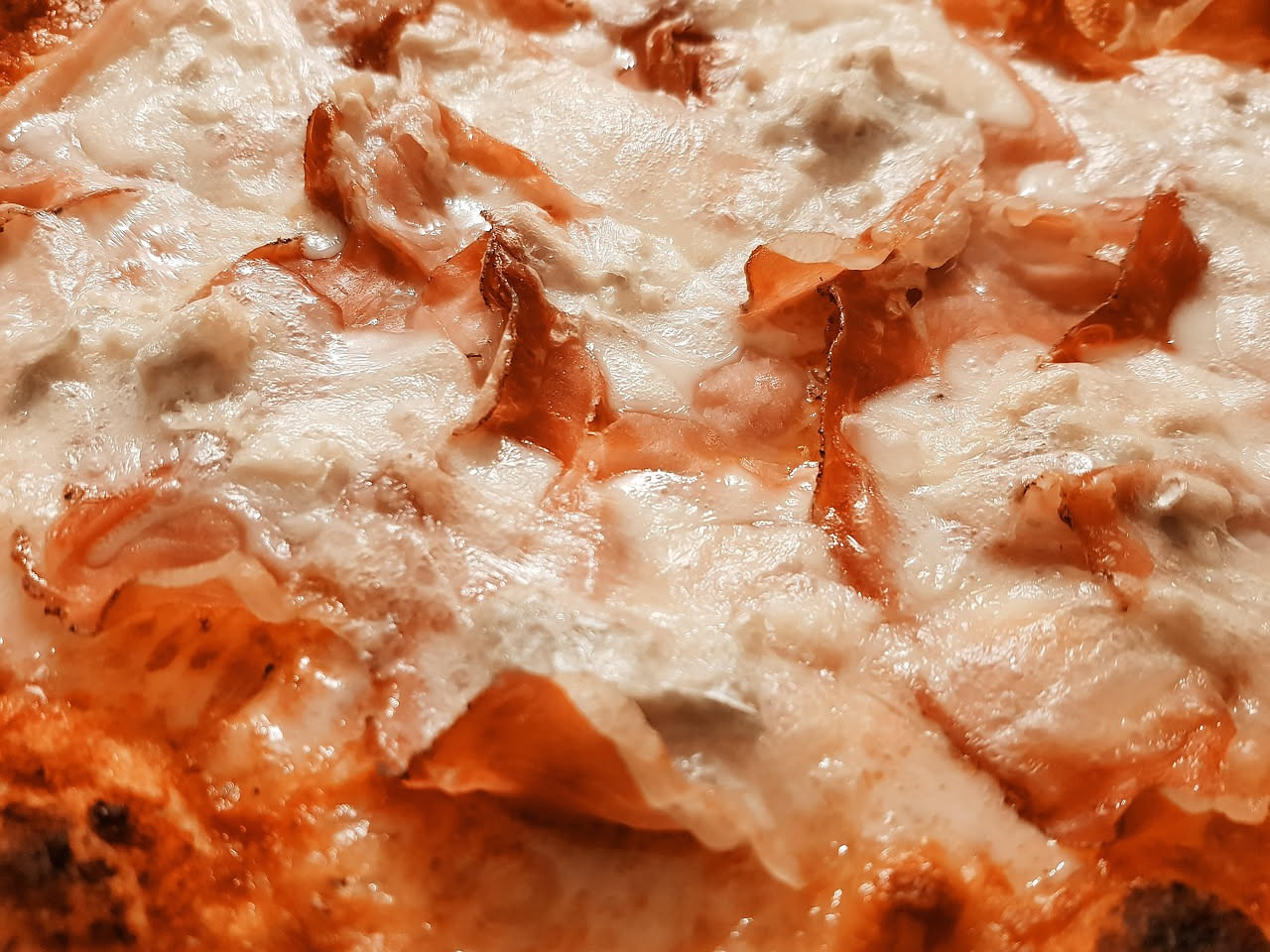 Formaggio gorgonzola tagliato a spicchi, che mostra le caratteristiche venature blu-verdi all'interno della pasta bianca, su tavolo in legno scuro
