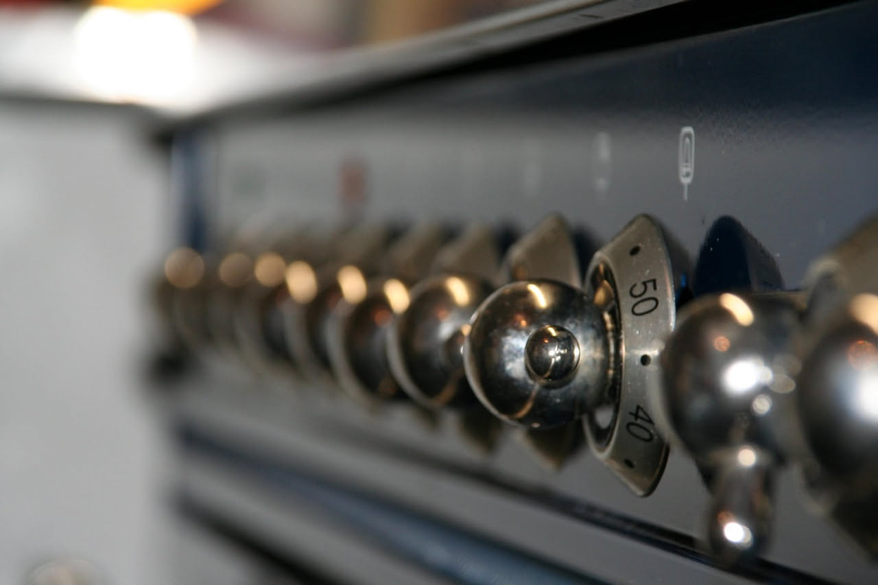 Interno di un forno moderno con sportello di vetro, lampada interna accesa, griglia al centro e due elementi riscaldanti visibili, uno in alto e uno in basso