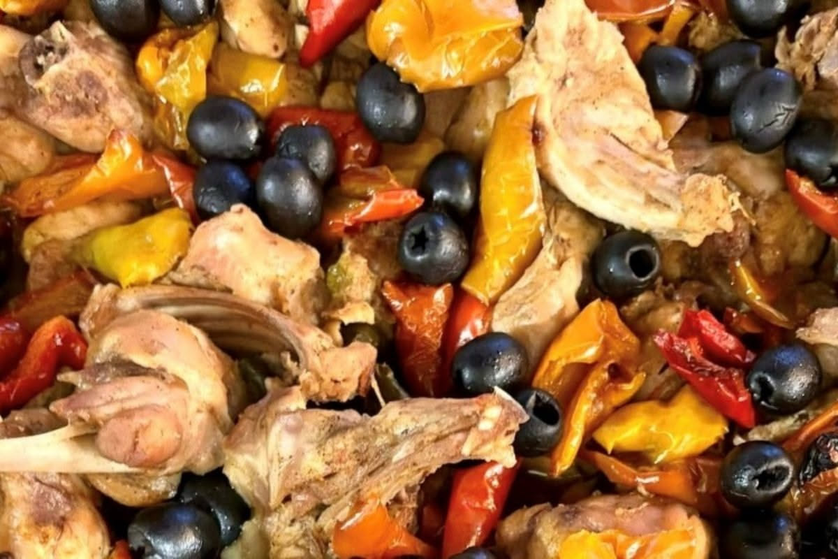 Pollo intero fresco su tagliere di legno con coltello da chef affilato, accanto utensili da cucina professionali su superficie bianca