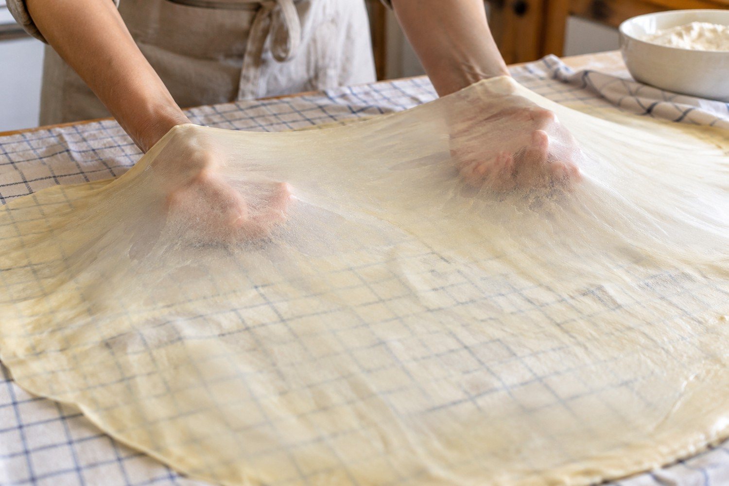 Il dorso delle mani allarga da sotto una sfoglia sottile e traslucida