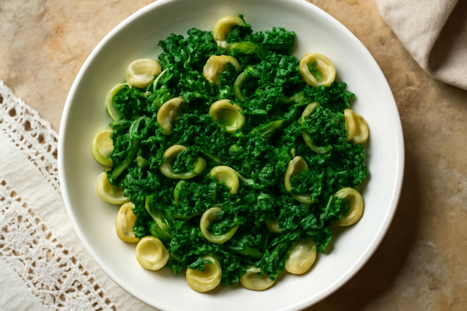 Piatto di orecchiette al dente con cime di rapa verde intenso, aglio dorato e olio brillante, servite in ciotola bianca, con gocce d'olio visibili sulla superficie