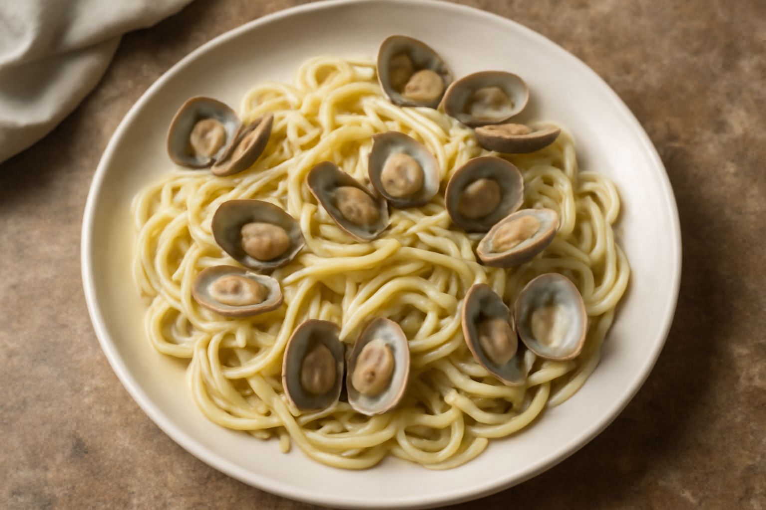 Piatto di pasta con vongole d'acqua dolce: spaghetti o linguine bianchi con molluschi aperti rosati visibili nel sugo, gocce di olio d'oliva lucido, prezzemolo verde fresco sparso, servito su piatto d